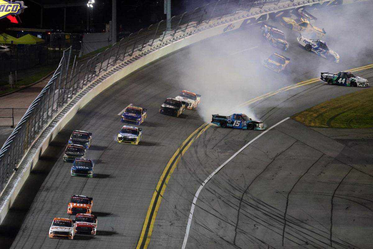 NASCAR Truck Series driver Parker Kligerman (75) leads the field to to the checkered flag as driver Tanner Gray (15), driver Layne Riggs (34), driver Bayley Currey (44) and driver Andres Perez de Lara (77) wreck during the Fresh From Florida 250 at Daytona International Speedway.
