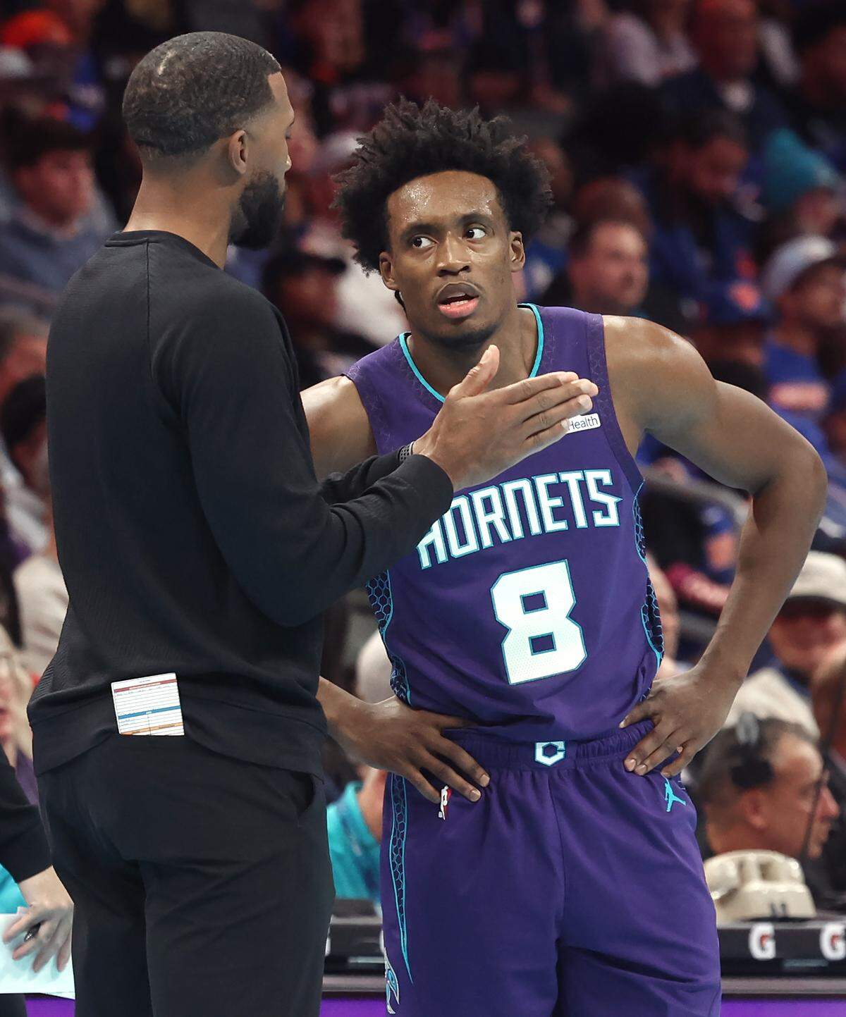 Charlotte Hornets head coach Charles Lee, left, speaks with guard Collin Sexton during action against the New York Knicks at Spectrum Center in Charlotte, North Carolina, on Wednesday, Nov. 26, 2025. The Knicks defeated the Hornets 129-101. 