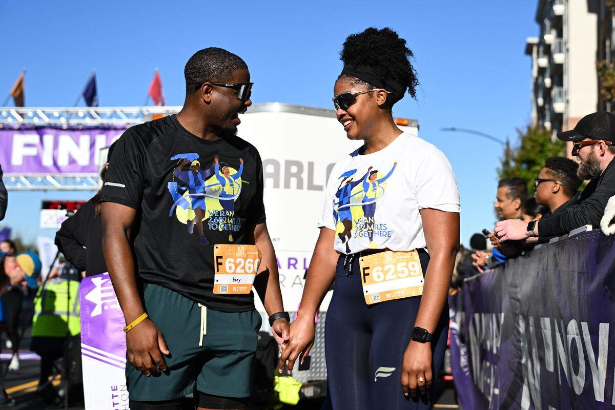 Grey Peoples, left, and fiancé Alexis Montague smile after taking part in the 20th annual Novant Health Charlotte Marathon on Saturday, Nov. 16, 2024, in Charlotte