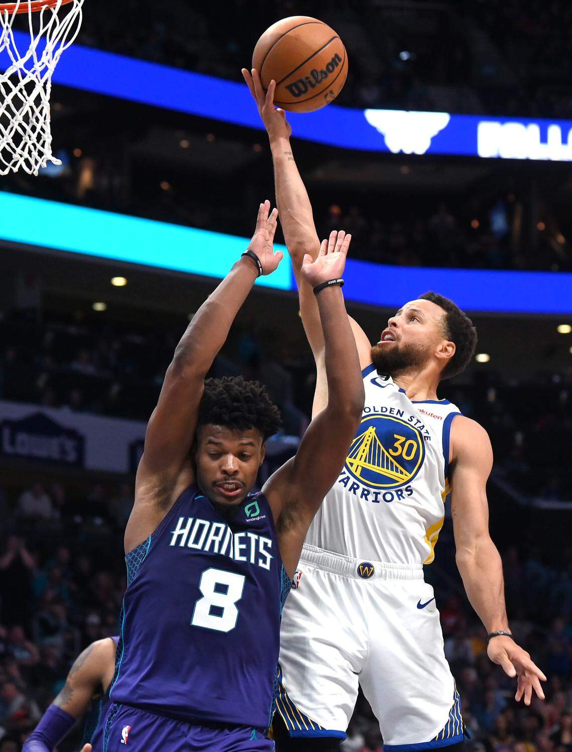 Golden State Warriors guard Stephen Curry, right, releases a running one-handed shot in the lane over Charlotte Hornets guard Dennis Smith Jr., left, during second half action at Spectrum Center on Saturday, October 29, 2022. The Hornets defeated the Warriors 120-113.