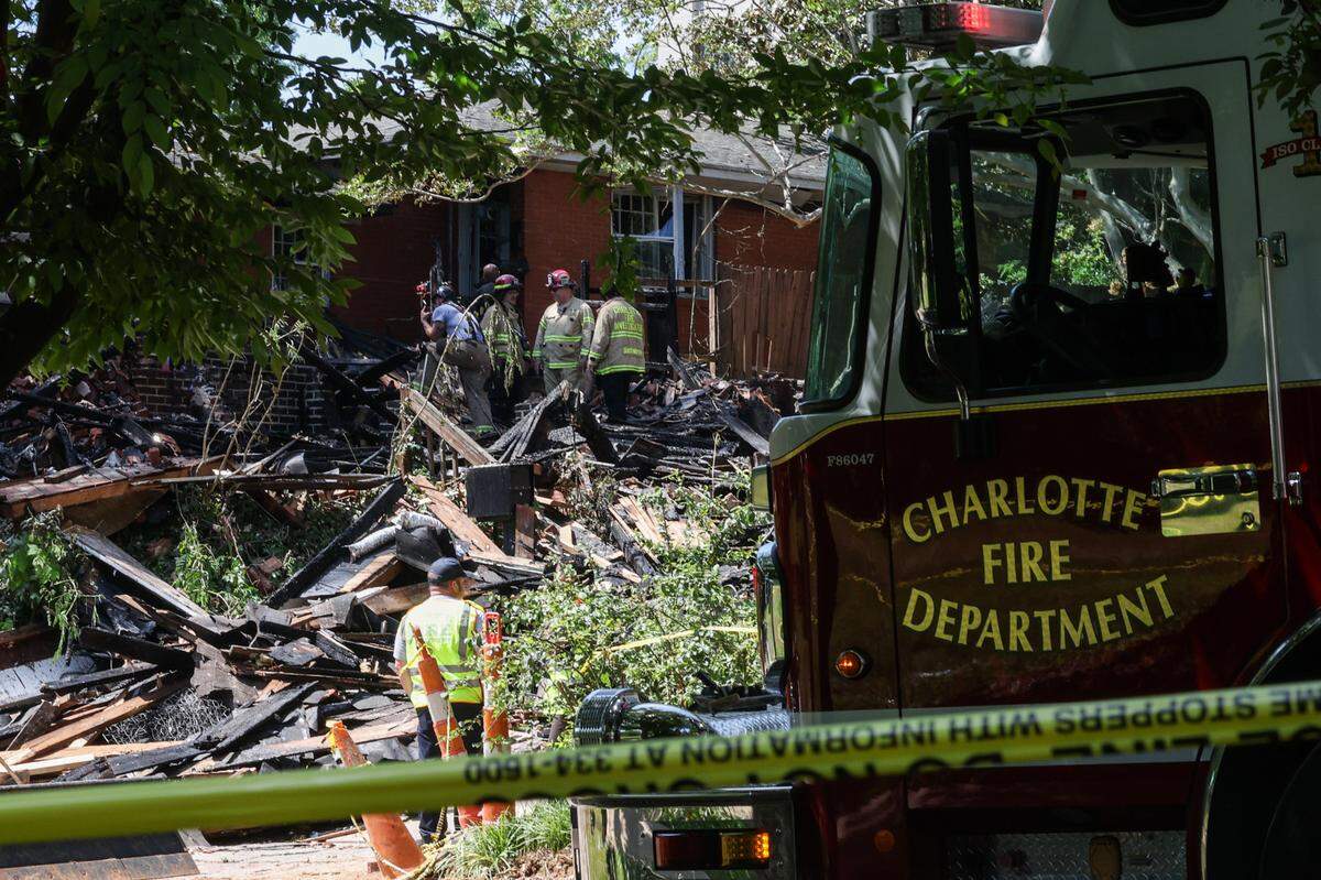 Charlotte Fire Department officials work at the site of a house fire near Freedom Park after an explosion was reported early morning in Charlotte, NC on Friday, May 2, 2025.