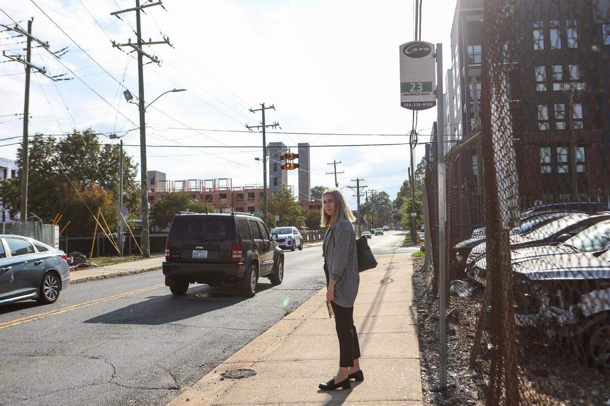 Genna Contino waits for a city bus along North Davidson Street on Monday, October, 9, 2022. Contino went without her car for a week to put Charlotte’s public transit system to the test.