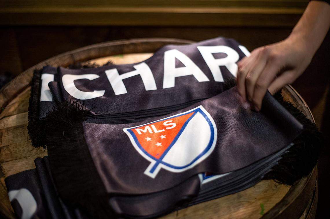 An employee hands out MLS scarves for patrons of Brewers at 4001 Yancey in Charlotte, NC on Tuesday, December 17, 2019. The celebration followed the official announcement of Charlotte becoming the 30th city to have Major League Soccer.