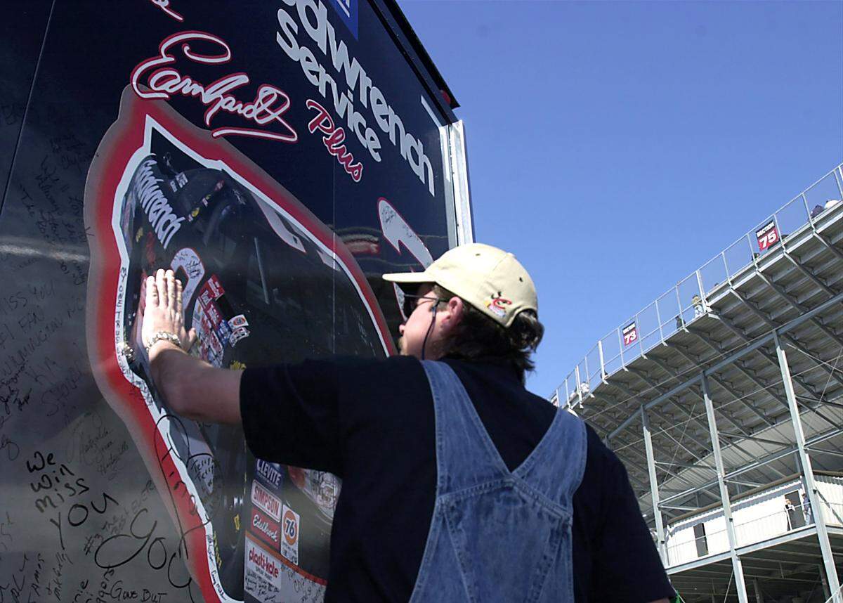 2/24/01 Frank Medlin of Wendell, NC places his hand on a Dale Earnhardt Goodwrench Service Plus transporter outside North Carolina Speedway Saturday afternoon. Said Medlin, “this was my way of saying goodbye, he was my hero, it’s hard to lose your hero.” JEFF SINER/STAFF