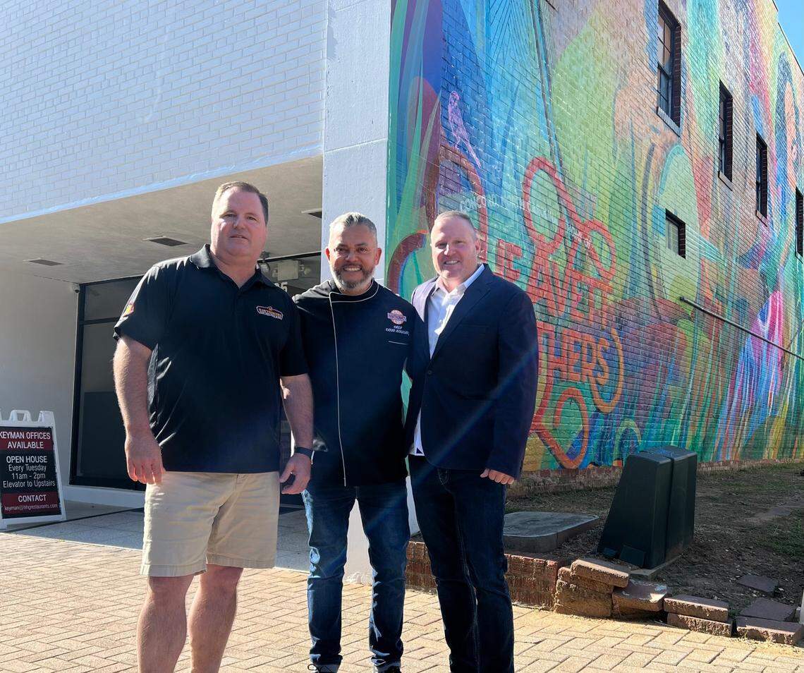 Hawthorne’s owners, from left, Michael Adams, Carlo Martinez and John Adams stand outside of the new Concord location next to “Bloom,” an Avett Brothers tribute mural by Caswell Turner.