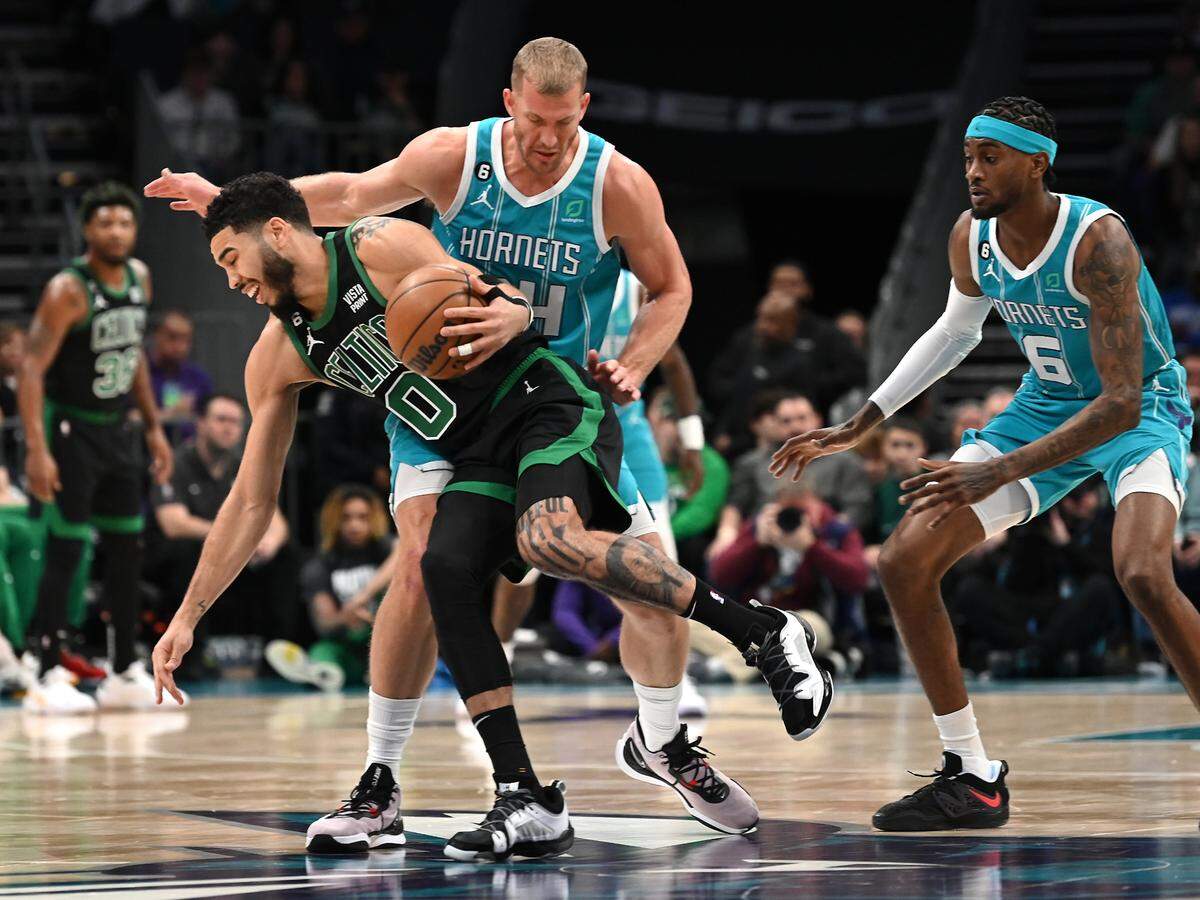 Boston Celtics forward Jayson Tatum, left, fights to get around Charlotte Hornets center Mason Plumlee, center and forward Jalen McDaniels, right, during first half action at Spectrum Center in Charlotte, NC on Monday, January 16, 2023.