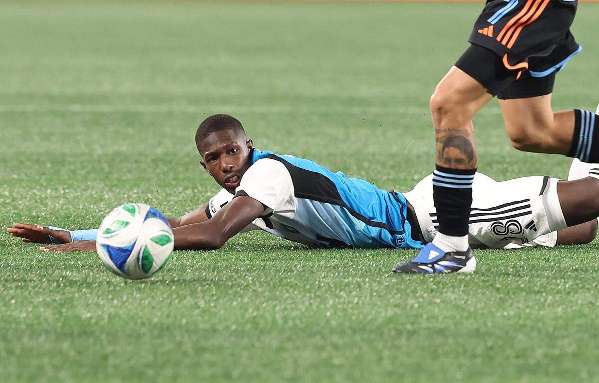 Charlotte FC midfielder Djibril Diani slides across the pitch at Bank of America Stadium as a New York City FC player takes control of the ball during action on Tuesday, October 28, 2025.