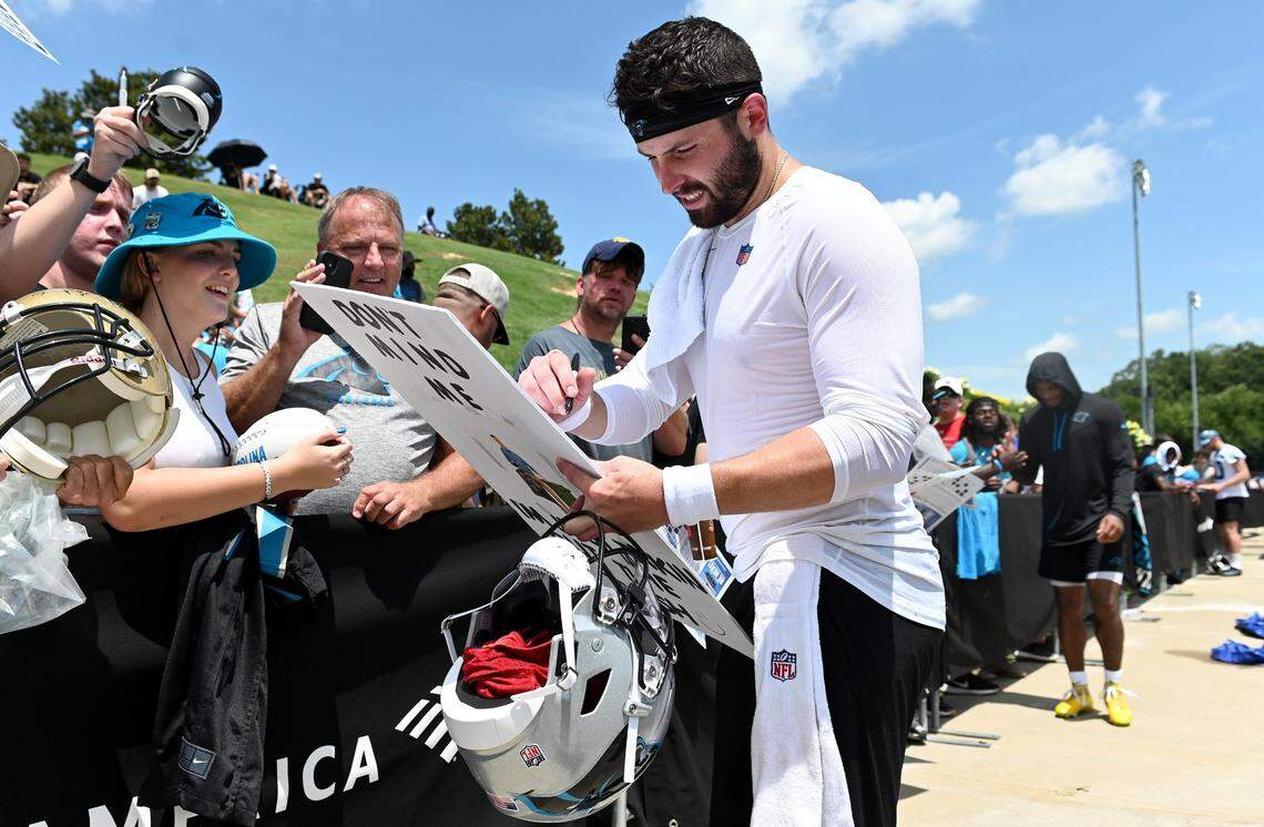 Carolina Panthers quarterback Baker Mayfield, right, stops to sign an autograph for a fan following practice on Wednesday, July 27, 2022 at Wofford College in Spartanburg, SC.