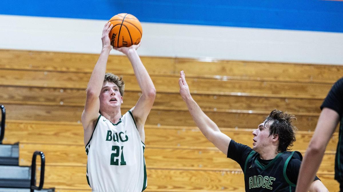 Country Day Buccaneers James Batten, left, shoots past a block by Catawba Ridge Copperheads Casey Fikis during the Phenom Hoops New Year’s Bash in Waxhaw, N.C., on Friday, December 27, 2024.