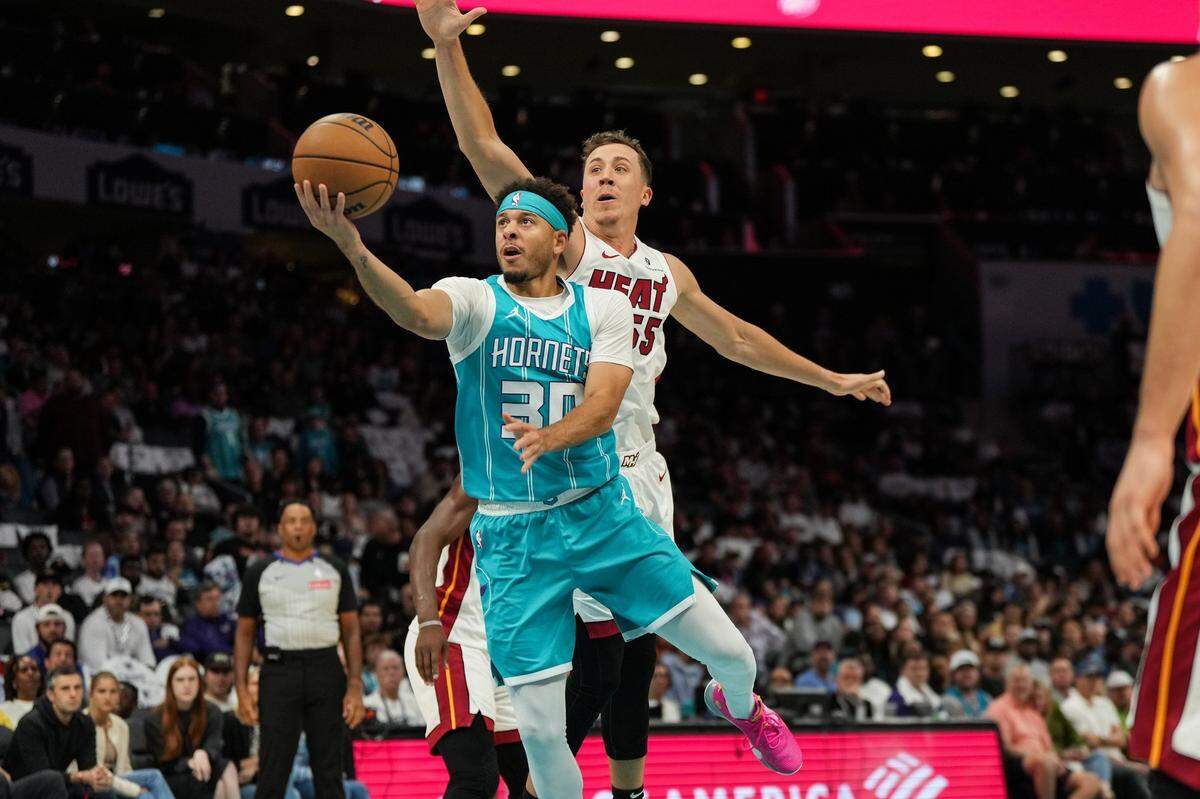 Charlotte Hornets guard Seth Curry (30) drives to the basket past Miami Heat forward Duncan Robinson (55) during the first half of an NBA basketball game, Saturday, Oct. 26, 2024, in Charlotte, N.C. (Charlotte Observer /Matt Kelley)