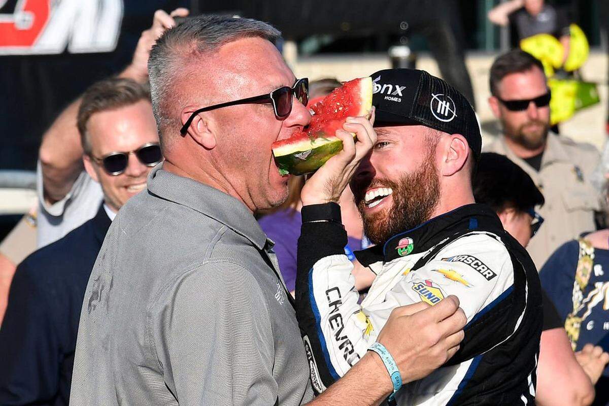 AUSTIN, TEXAS - MARCH 27: Ross Chastain, driver of the #1 ONX Homes/iFly Chevrolet, celebrates by feeding T. J. Puchyr, co-owner of Spire Motorsports a watermelon after winning the NASCAR Cup Series Echopark Automotive Grand Prix at Circuit of The Americas on March 27, 2022 in Austin, Texas. (Photo by Logan Riely/Getty Images)