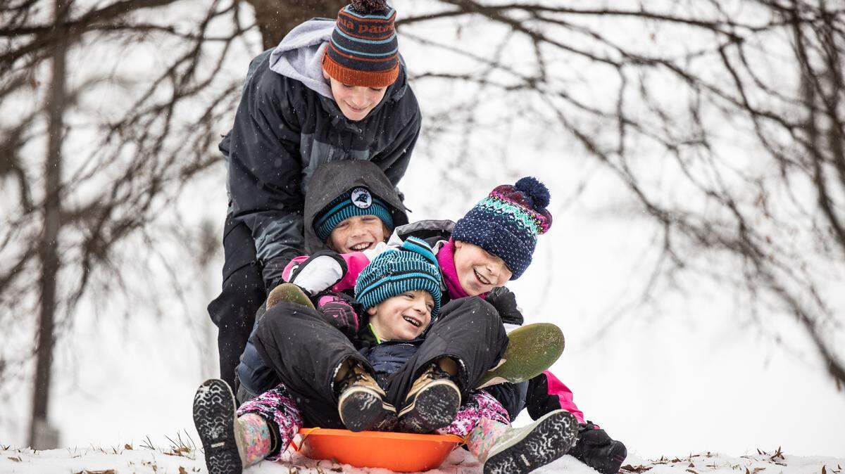 Owen Moore, 13, pushes his siblings on a sled down a hill, back to front, Cormac, 12, Agnes, 10, and Eamon, 8, during winter weather in Charlotte, N.C., on Sunday, January 16, 2022. 

