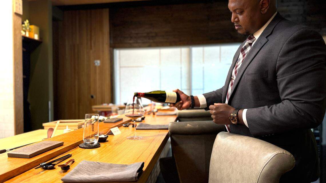 At Omakase by Prime Fish, Terrell Johnson pours a glass of 2020 Château de Chamirey, a French wine whose price by the glass could jump from $50 to as much as $150 after April 2 if President Trump’s proposed wine tariffs go into effect.