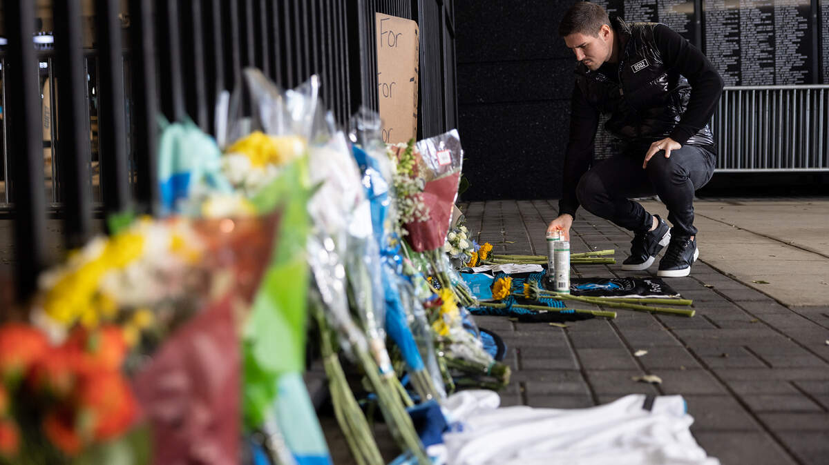 Charlotte FC goalkeeper Kristijan Kahlina lays a candle in front of a memorial during a vigil for Charlotte FC defender Anton Walkes Charlotte, N.C., on Thursday, January 19, 2023.