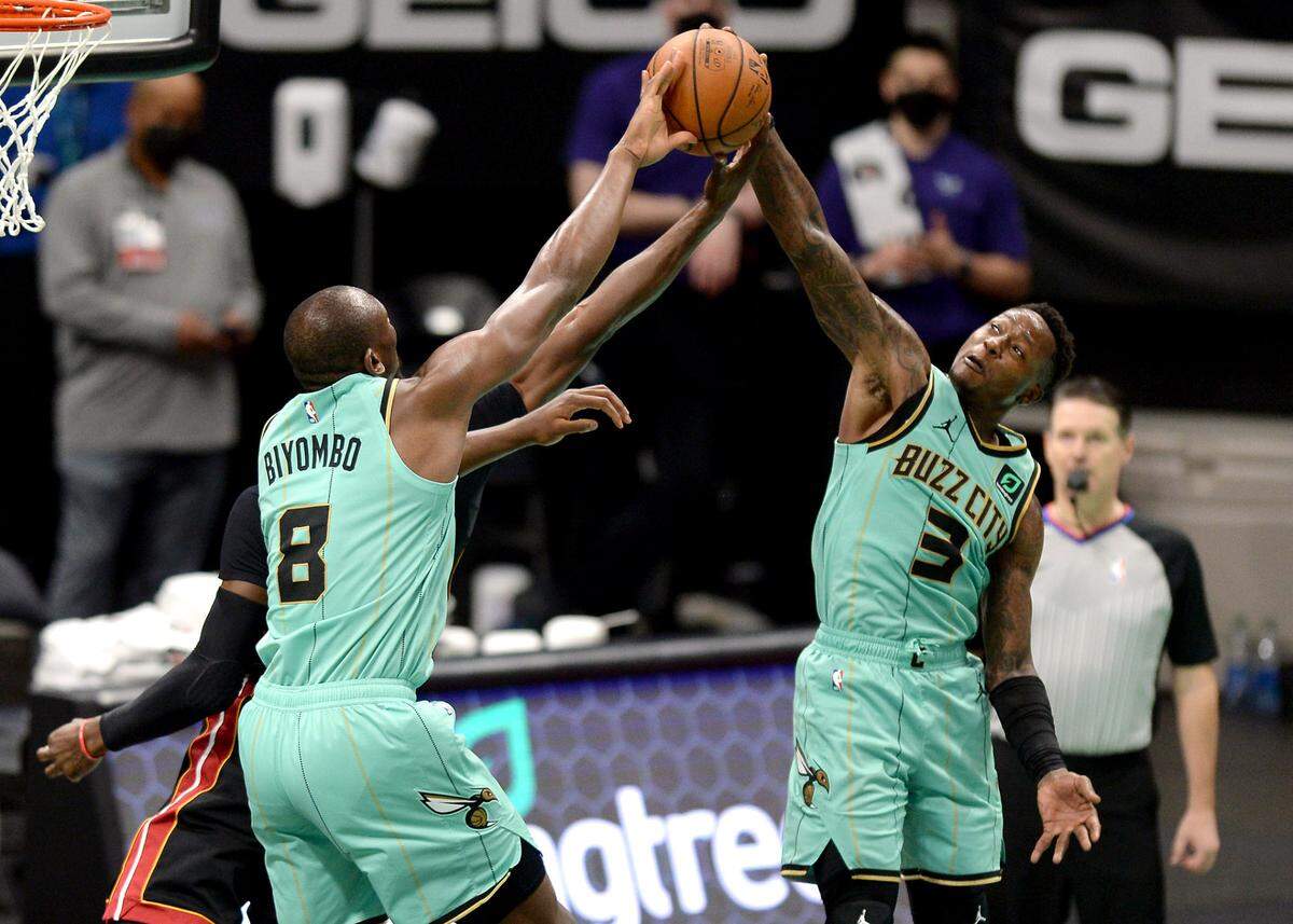 Charlotte Hornets center Bismack Biyombo, left and guard Terry Rozier, right, converge on a Miami Heat player’s drive in Friday’s victory at Spectrum Center.