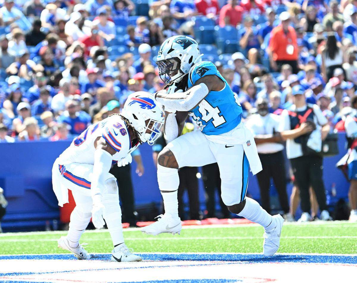 Carolina Panthers running back Mike Boone (34) scores a touchdown as Buffalo Bills safety Kendall Williamson (36) defends in the second quarter Saturday at Highmark Stadium.