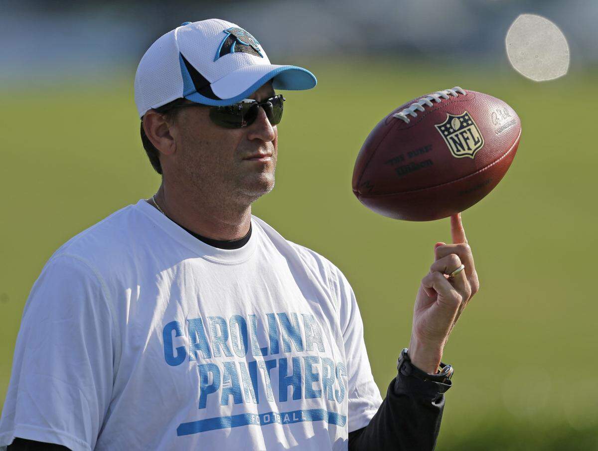 File-This July 26, 2013, file photo shows Carolina Panthers offensive coordinator Mike Shula spinning a football on his finger during practice at NFL football training camp in Spartanburg, S.C. Hall of Fame coach Don Shula is rooting for his son Mike and the Panthers to join his 1972 Miami Dolphins as the only undefeated Super Bowl champion. (AP Photo/Chuck Burton, File)