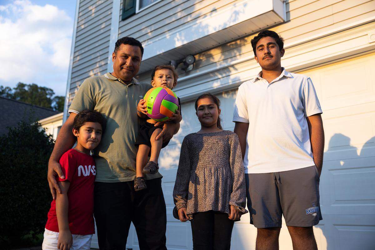 Mohammad Ihsan Kamran poses for a portrait with his family in his front yard in Charlotte, N.C., on Monday, August 22, 2022.