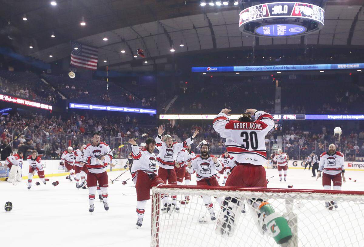 Charlotte goaltender Alex Nedeljkovic begins the celebration as his teammates rush onto the ice after the horn sounded in Game 5 of the AHL Calder Cup Finals in Rosemont, Ill., on Saturday, a 5-3 victory over the Chicago Wolves that clinched the Checkers’ first championship in the league.