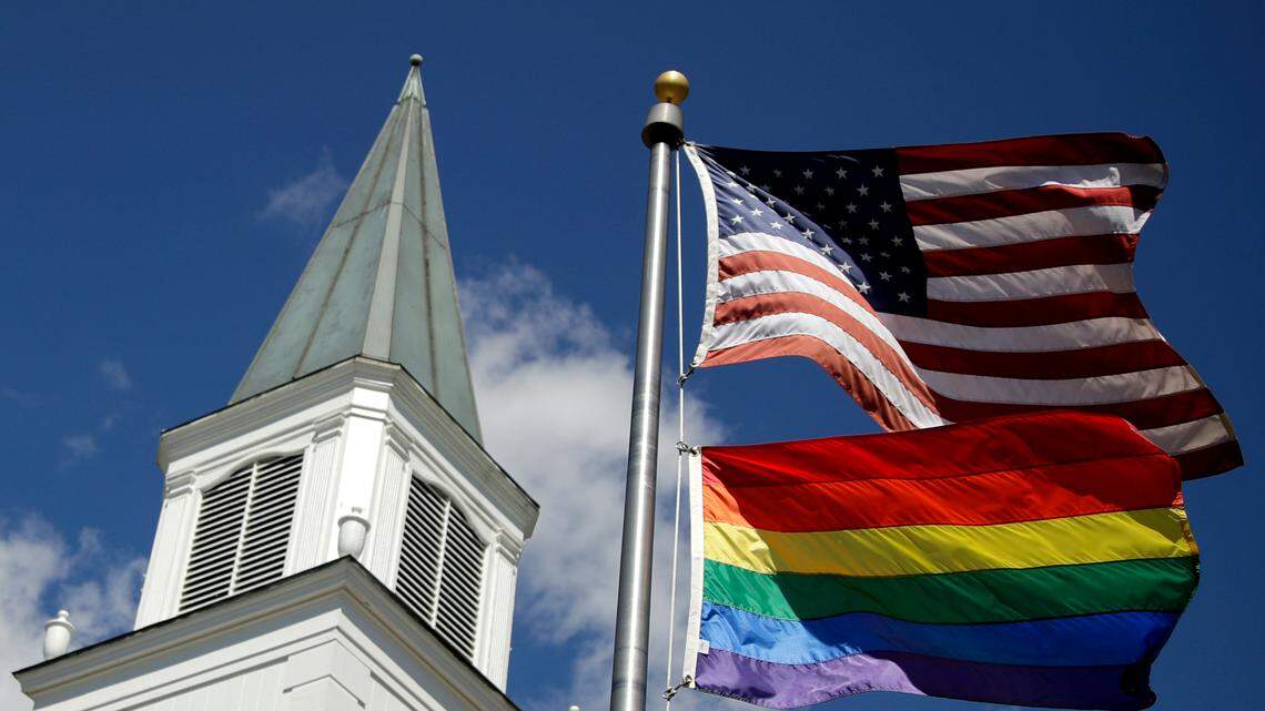 FILE - In this April 19, 2019 file photo, a gay pride rainbow flag flies along with the U.S. flag in front of the Asbury United Methodist Church in Prairie Village, Kan.