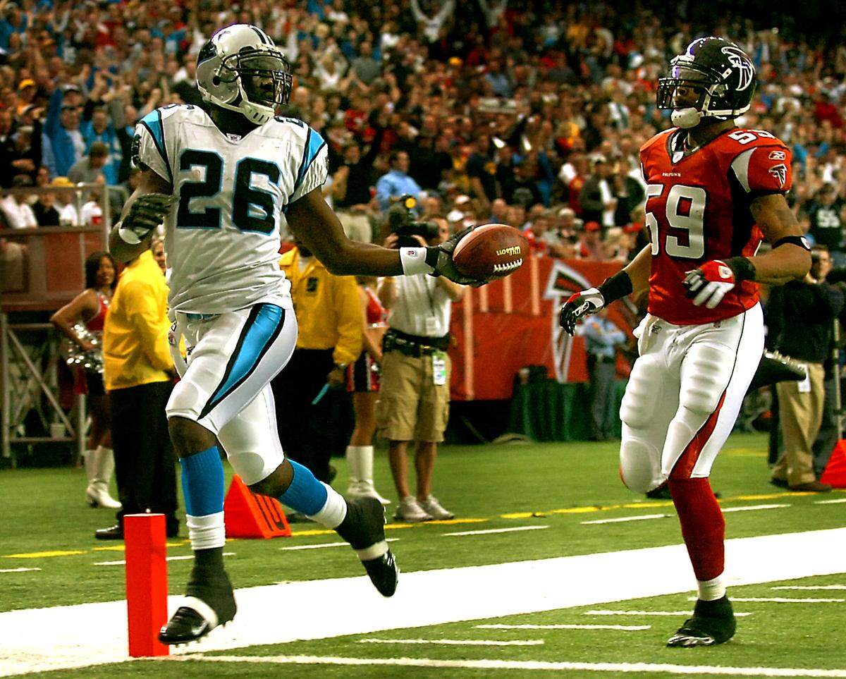 01/01/06: Carolina Panthers’ DeShaun Foster (left) taunts Atlanta Falcons’ Michael Boley with the football as Foster crosses into the end zone after clipping off a 70-yard run for a touchdown during Carolina’s 44-11 win over Atlanta on Jan. 1, 2006, at the Georgia Dome in Atlanta, GA.