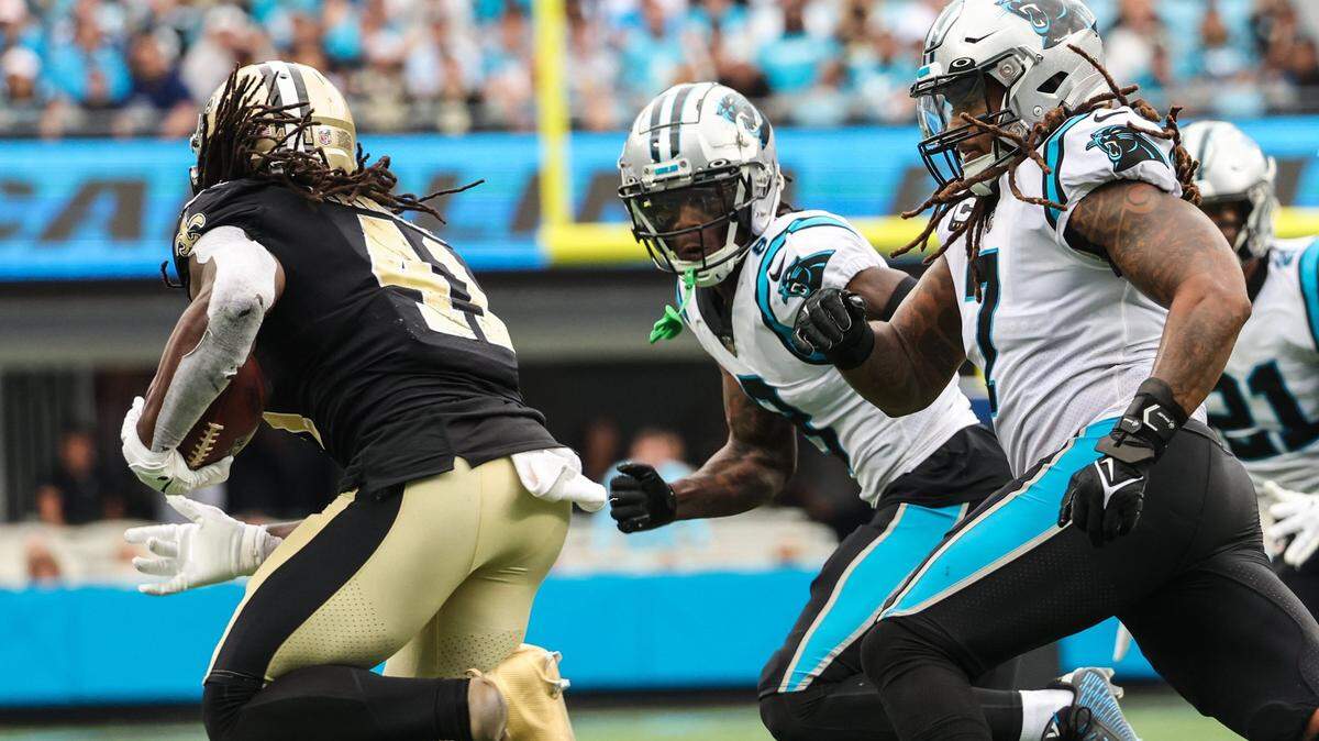 Panthers cornerback Jaycee Horn, center, and linebacker Shaq Thompson, right, pursue Saints running back Alvin Kamara during the game at Bank of America Stadium on Sunday, September 25, 2022 in Charlotte, NC.