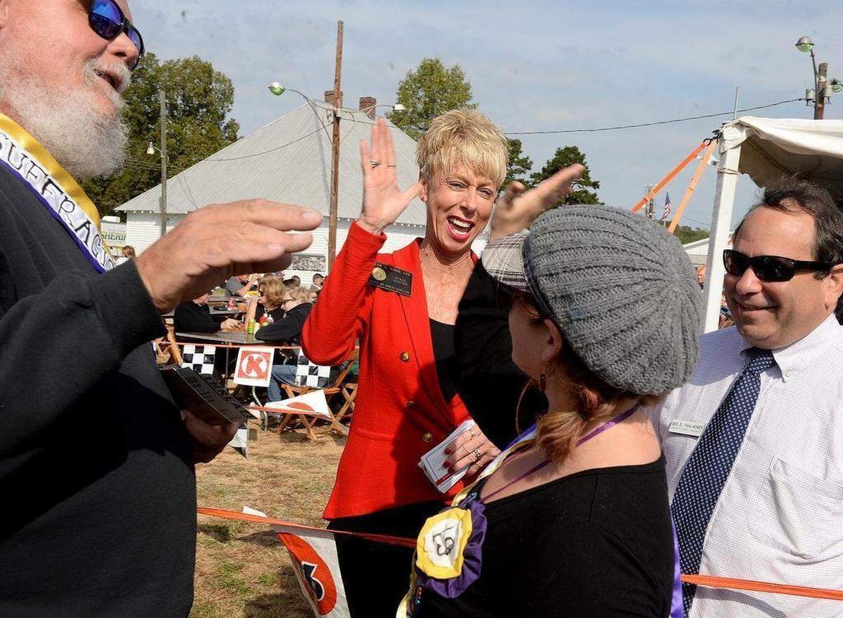 Beth Wood, NC State Auditor, high-fives Cat Lyons at the Mallard Creek Barbecue Oct. 27, 2016.