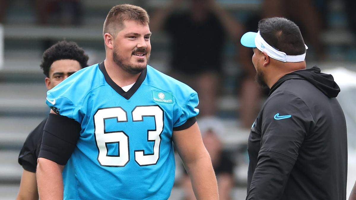 Carolina Panthers center Austin Corbett, center, speaks to a coach after snapping the ball to quarterback Bryce Young during training camp practice on Thursday, July 25, 2024.