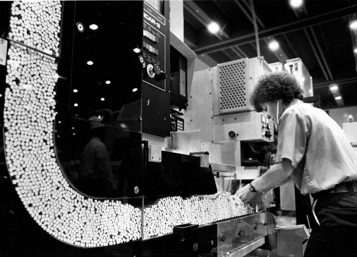 Worker checks on filter-attaching process Philip Morris plant in 1983