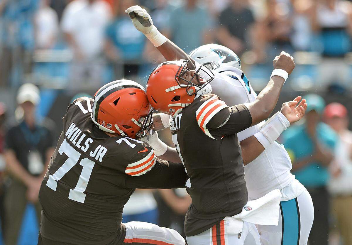 Carolina Panthers defensive end Brian Burns, right, rushes into the backfield to make a hit on Cleveland Browns quarterback Jacoby Brissett, center, during fourth quarter action at Bank of America Stadium on Sunday, September 11, 2022. Burns was called for roughing the passer on the play. The Browns defeated the Panthers 26-24.