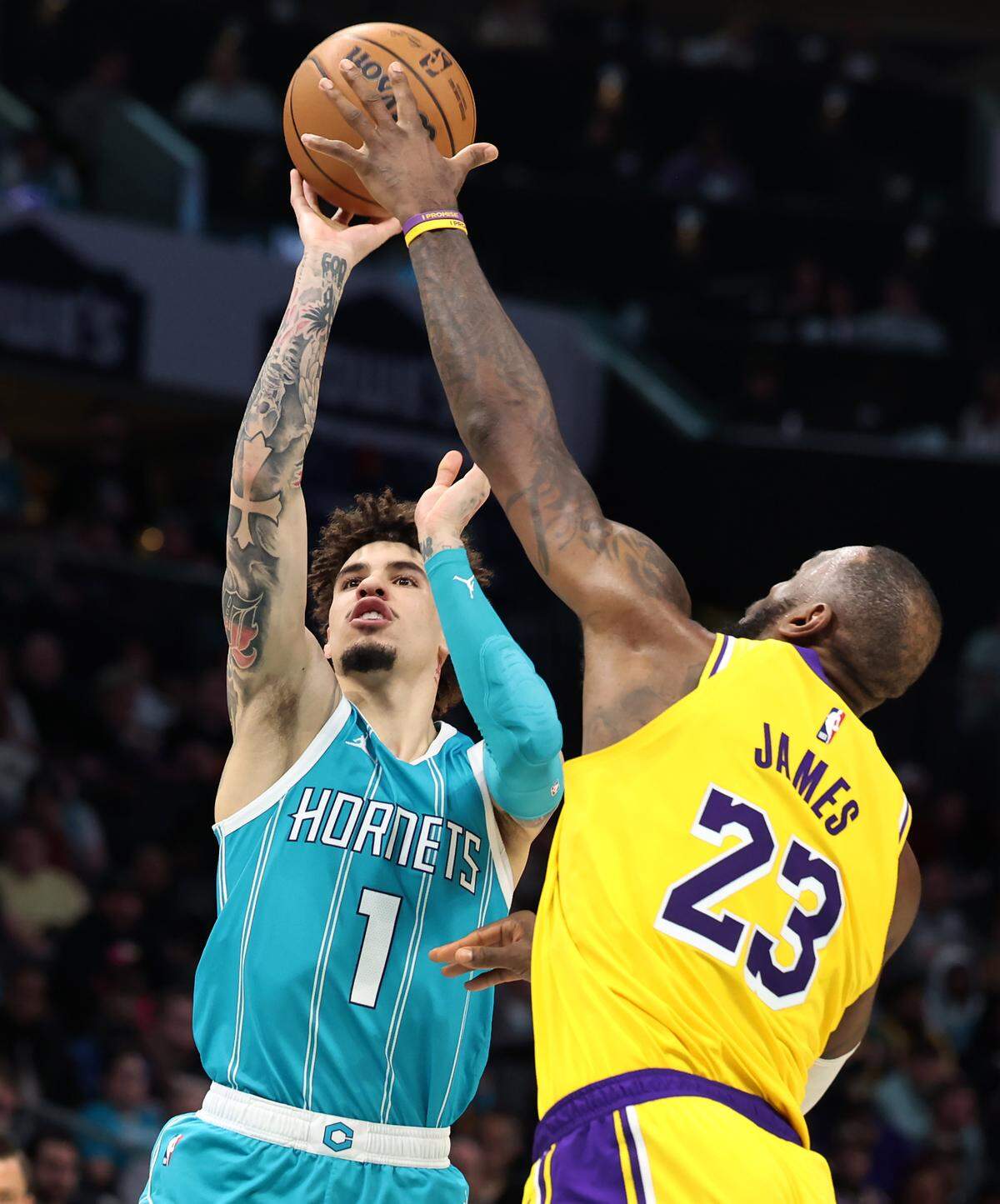 Charlotte Hornets guard LaMelo Ball (left) tries to shoot over LeBron James in January.