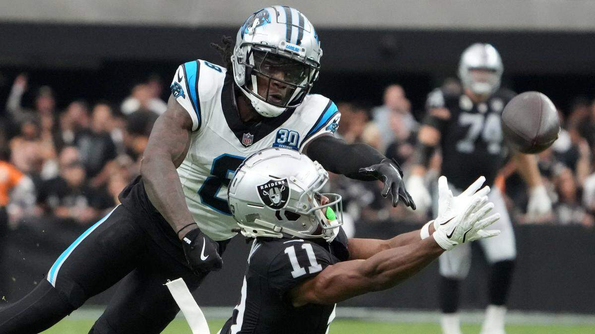 Sep 22, 2024; Paradise, Nevada, USA; Las Vegas Raiders wide receiver Tre Tucker (11) attempts to catch the ball against Carolina Panthers cornerback Jaycee Horn (8) in the second half at Allegiant Stadium. Mandatory Credit: Kirby Lee-Imagn Images