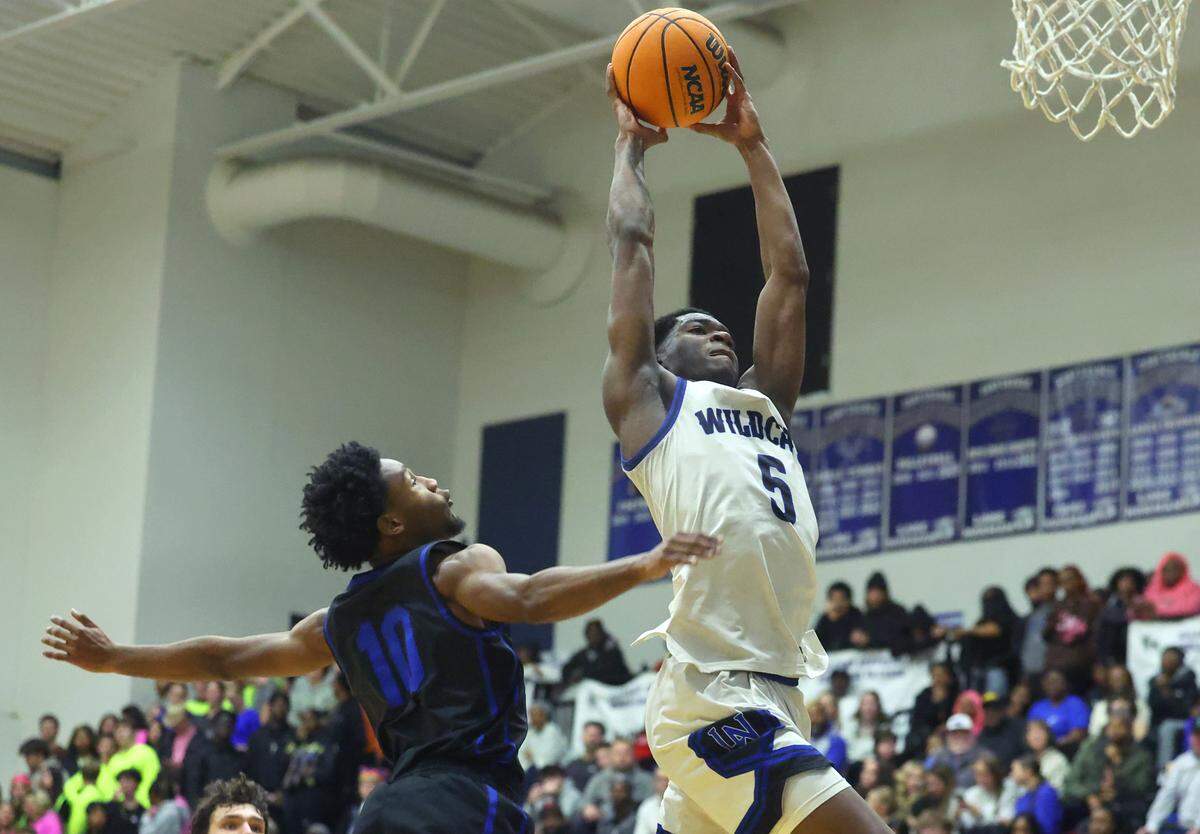 Lake Norman’s Tre McKinnon, right, glides down the lane past Mooresville defender Chanse Bost, left, during action on Wednesday, January 22, 2025 at Lake Norman High School. Lake Norman defeated Mooresville 99-71.
