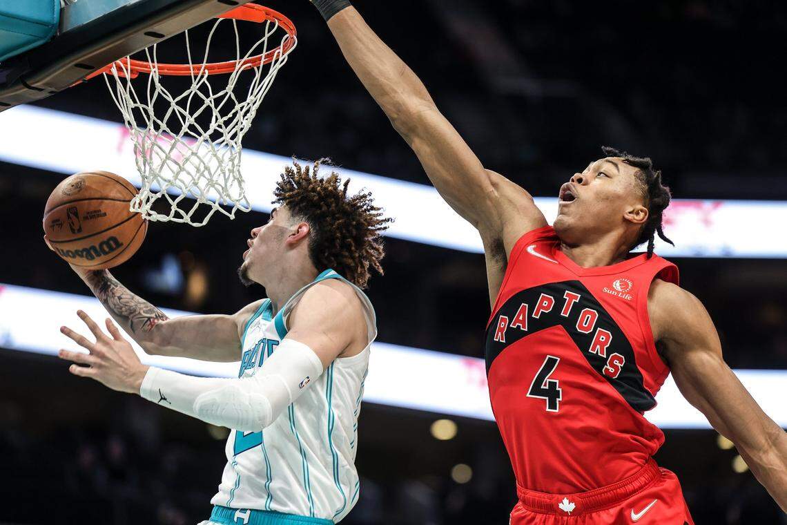 Charlotte Hornets LaMelo Ball, left, shoots past Toronto Raptors Scottie Barnes at the Spectrum Center In Charlotte, N.C., on Monday, February 7, 2022.