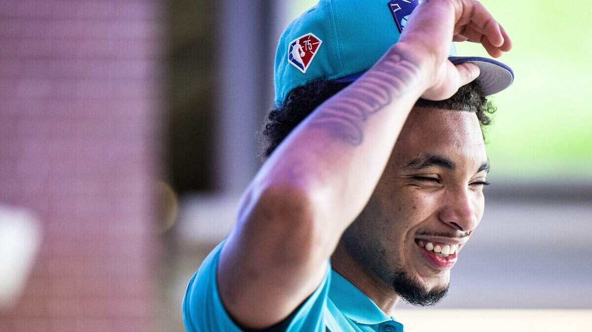 Charlotte Hornets draft pick, James Bouknight, puts on a Hornets hat during a press conference at the Spectrum Center in Charlotte, N.C., on Friday, July 30, 2021.