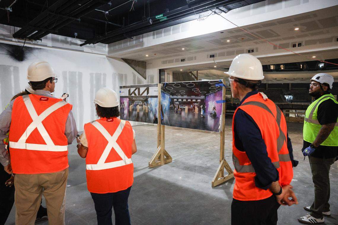 Media members look at renderings of improvements coming to the arena entrance from the concourse during a Spectrum Center hardhat tour Monday.