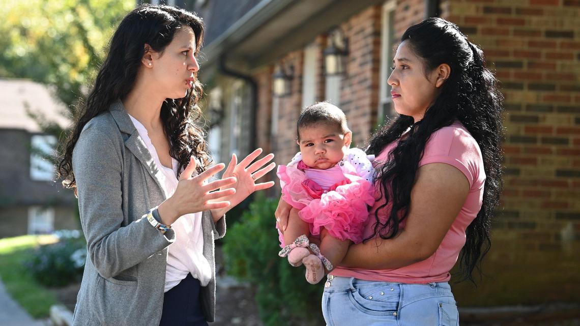Charlotte Center for Legal Advocacy paralegal advocate Elizabeth Setaro, left, speaks with Elida Valdez, right, as she holds her five-month old daughter Sofia Johana, center, on Friday, October 7, 2022. Valdez has not received a new EBT card in months.
