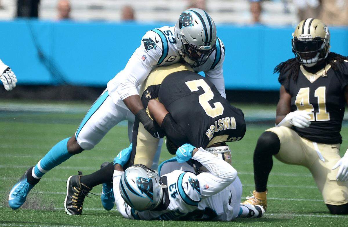 Carolina Panthers defensive end Brian Burns, left and linebacker Haason Reddick, bottom, sack New Orleans Saints quarterback Jameis Winston during first quarter action at Bank of America Stadium in Charlotte, NC on Sunday, September 18, 2021.