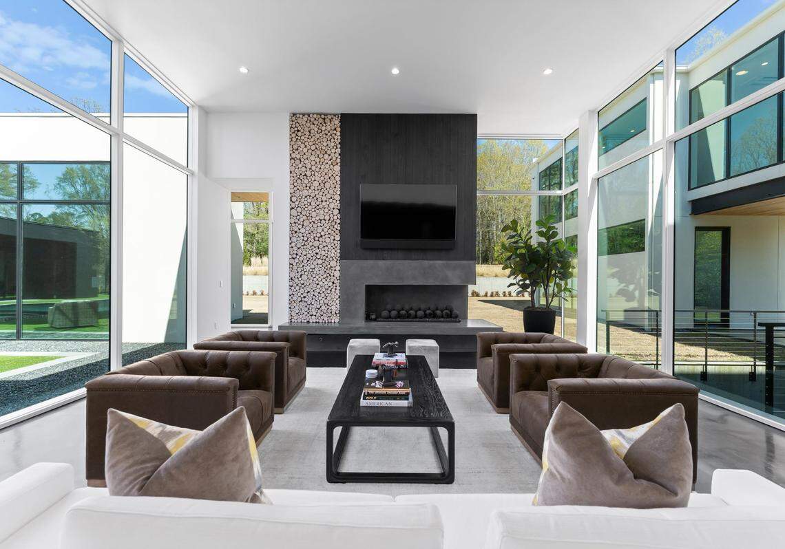 Expansive open living areas are defined by sleek lines and floor-to-ceiling glass, blending the indoors with the outdoors and offering views of the infinity-edge pool, elegant gardens, central courtyard, and sweeping lawn.