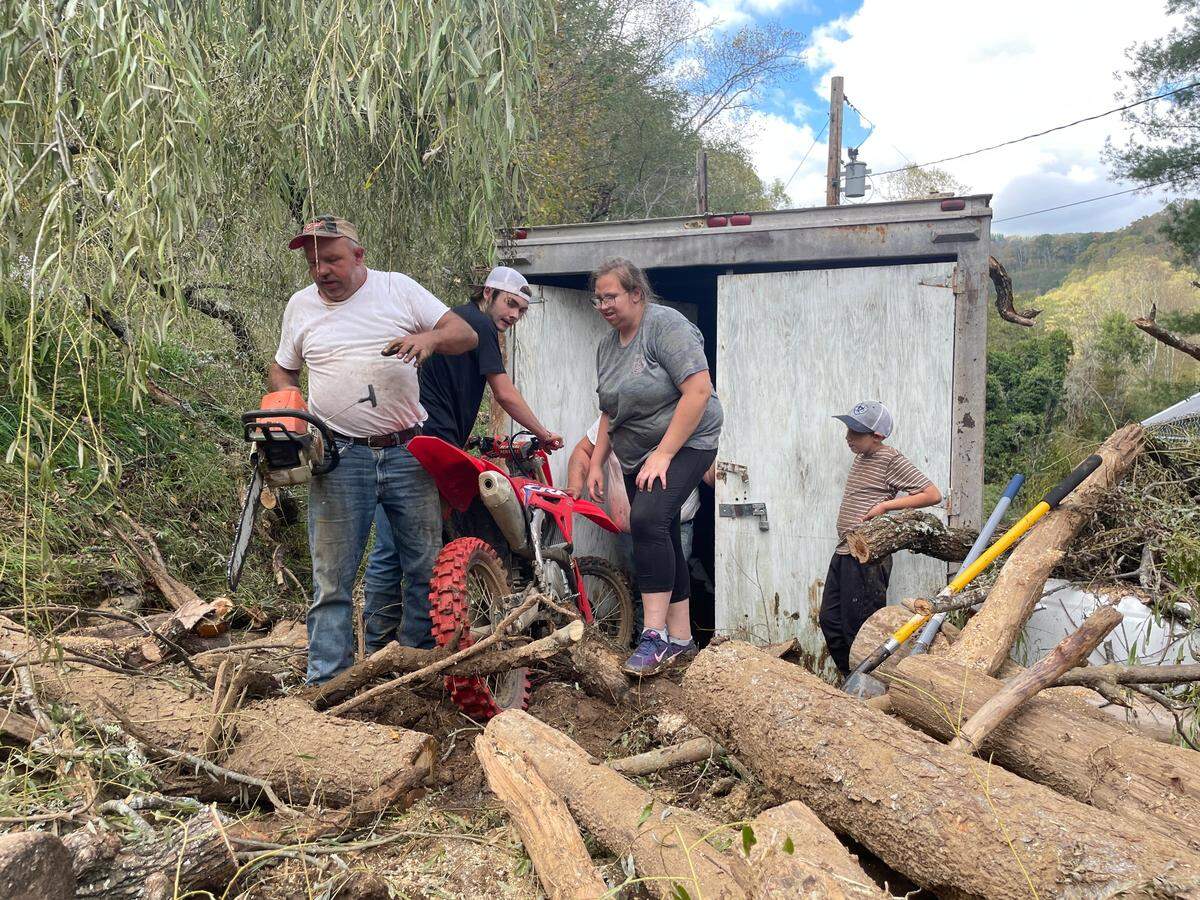 Logan Brown, 17, and his family tug dirt bikes from the shed next to their home on Thursday, Oct. 3, 2024, nearly a week after remnants of Hurricane Helene flooded it with logs and mud.