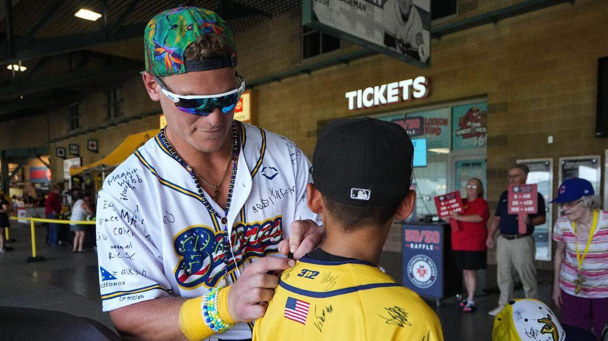 Savannah Bananas’ Eric Jones Jr. (3) autographs a jersey of a fan during the team’s recent stop in Indianapolis. (Grace Hollars / Indianapolis Star)
