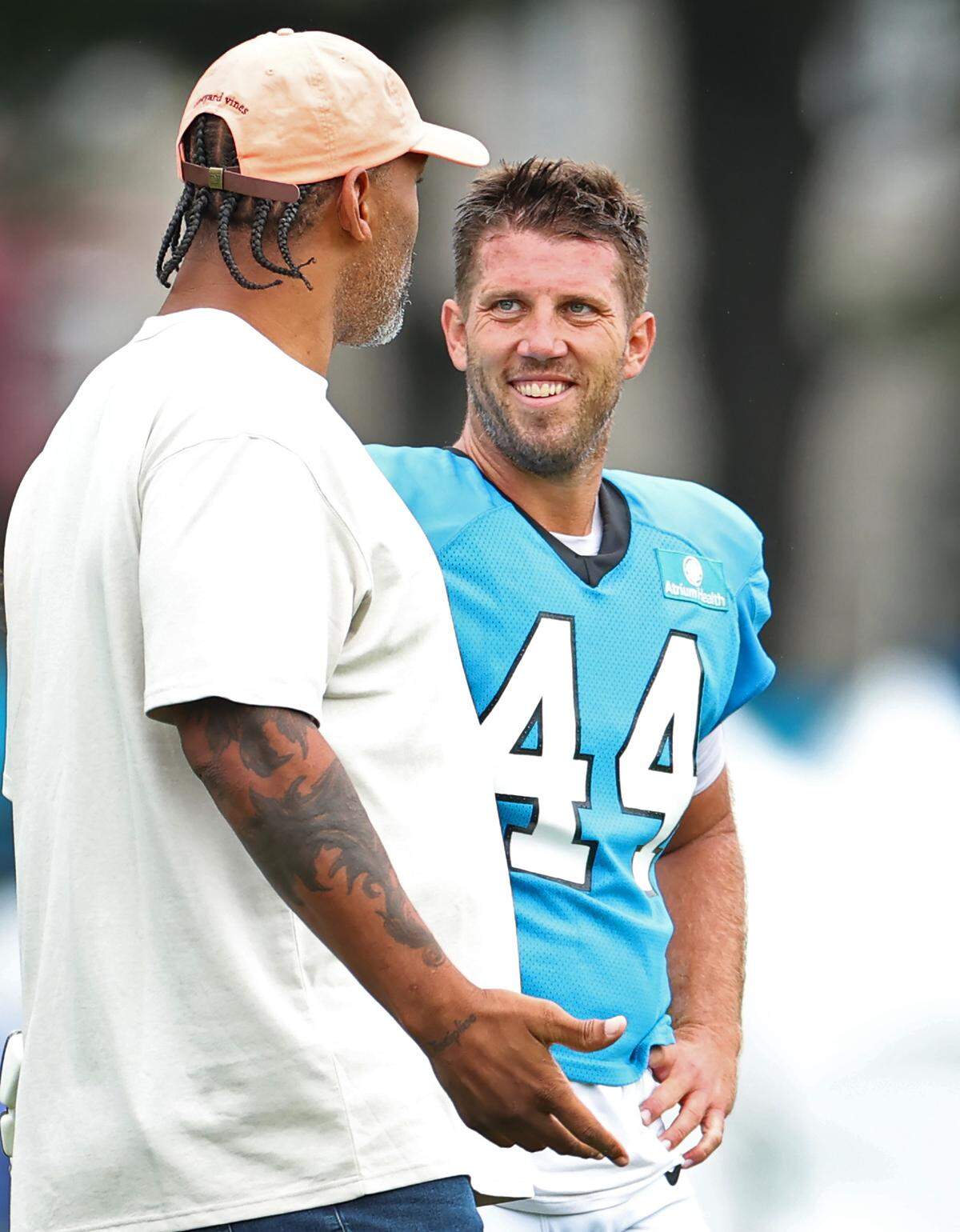 Former Carolina Panthers defensive end and NFL Hall of Fame member Julius Peppers, left, speaks with long snapper JJ Jansen, right, during the team’s practice on Tuesday, August 6, 2024.