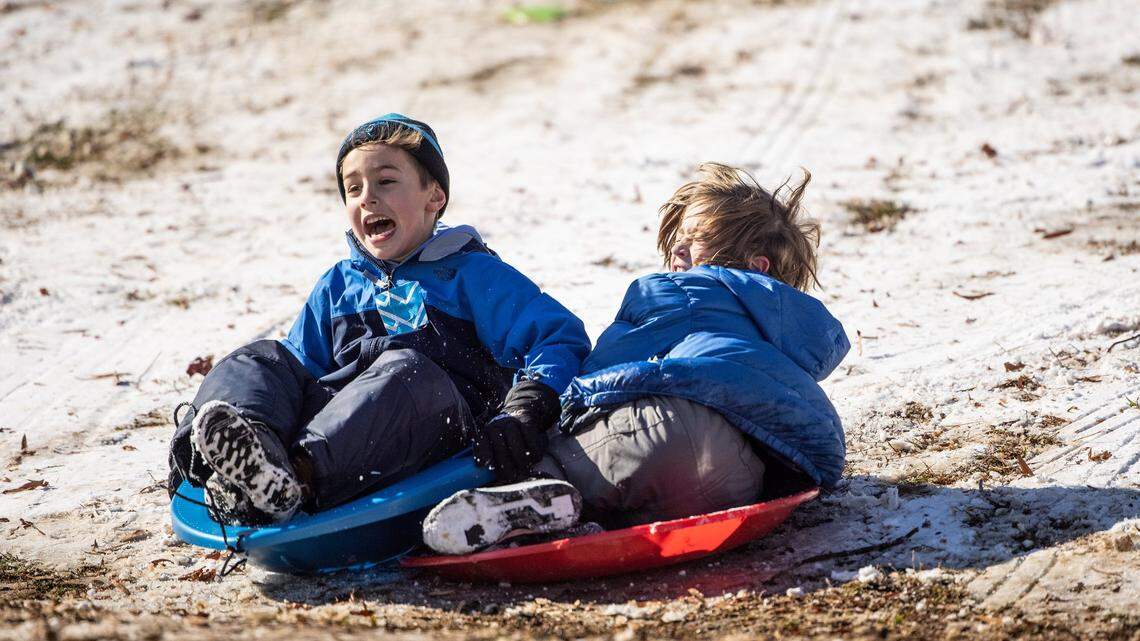 Children collide while sledding in Charlotte, N.C., on Saturday, January 22, 2022. Will we see snow this winter? Prospects are dicey, meteorologists say.
