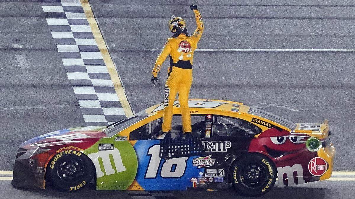 Kyle Busch celebrates on the top of his car after winning the NASCAR Clash auto race at Daytona International Speedway, Tuesday, Feb. 9, 2021, in Daytona Beach, Fla. (AP Photo/John Raoux)