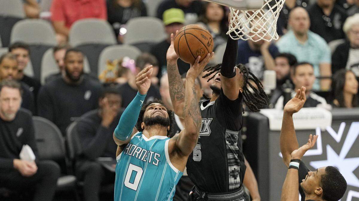 Charlotte Hornets forward Miles Bridges (0) drives to the basket against San Antonio Spurs guard Stephon Castle (5) during the first half at Frost Bank Center.