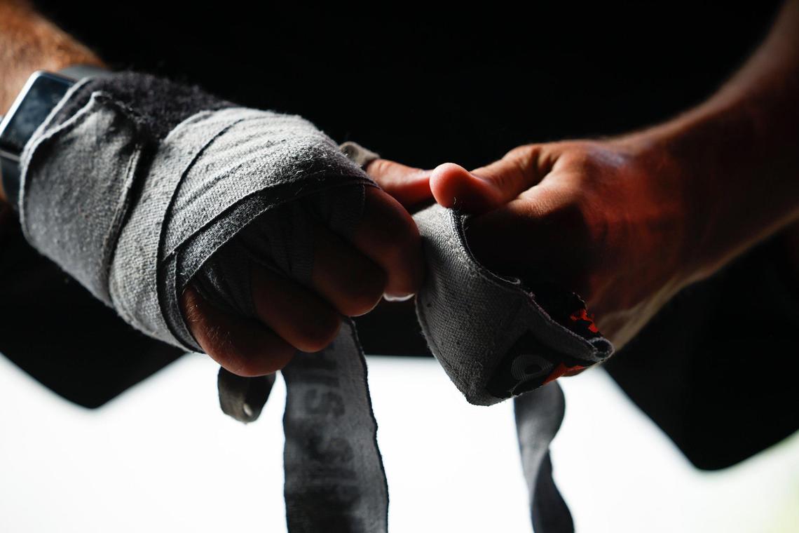 Justin Ashley, an American history teacher at Community House Middle School, wraps his hands before a training session at Round9 fitness studio in Charlotte. Over the years as educator Ashley has battled depression, anxiety and dependence on prescription drugs, he has found boxing as one of the many ways to help cope with stress.