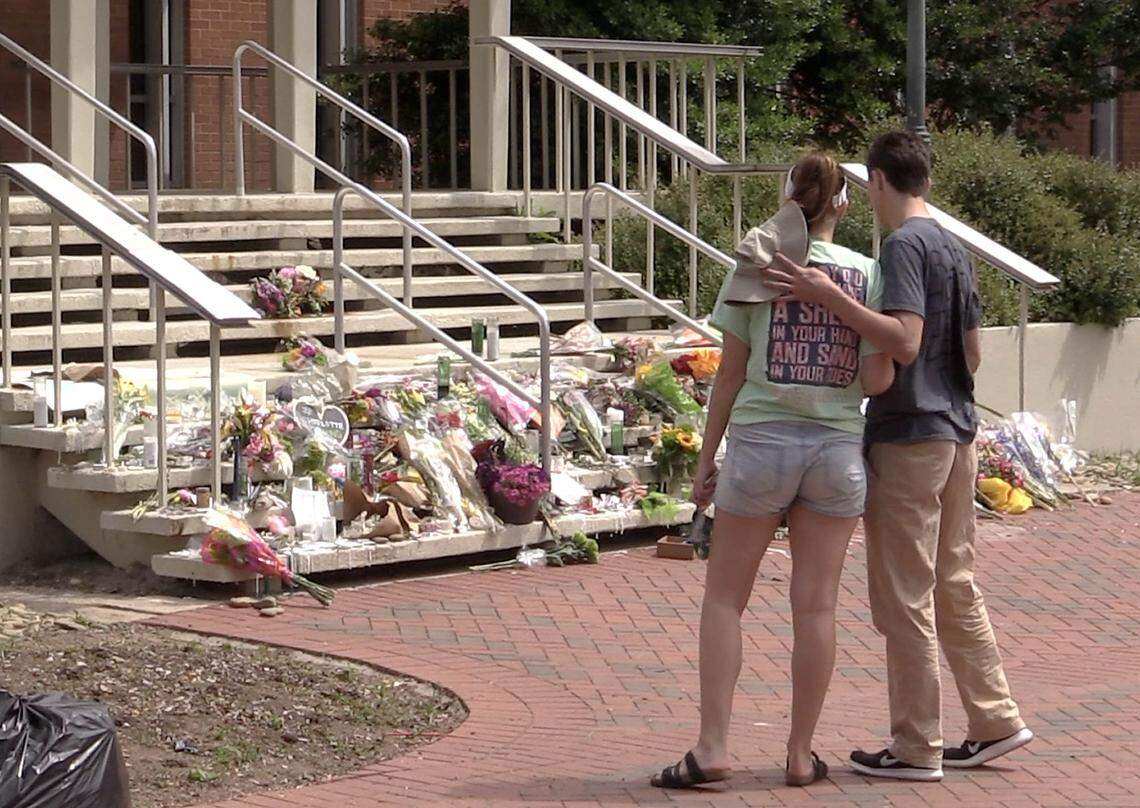 People pay respects at a memorial set up on the steps of the Kennedy Building on the campus of UNC-Charlotte, after the shooting there on April 30. Kevin Westmoreland, the father of Riley Howell’s longtime girlfriend Lauren Westmoreland, visited the classroom in search of answers about the shooting.