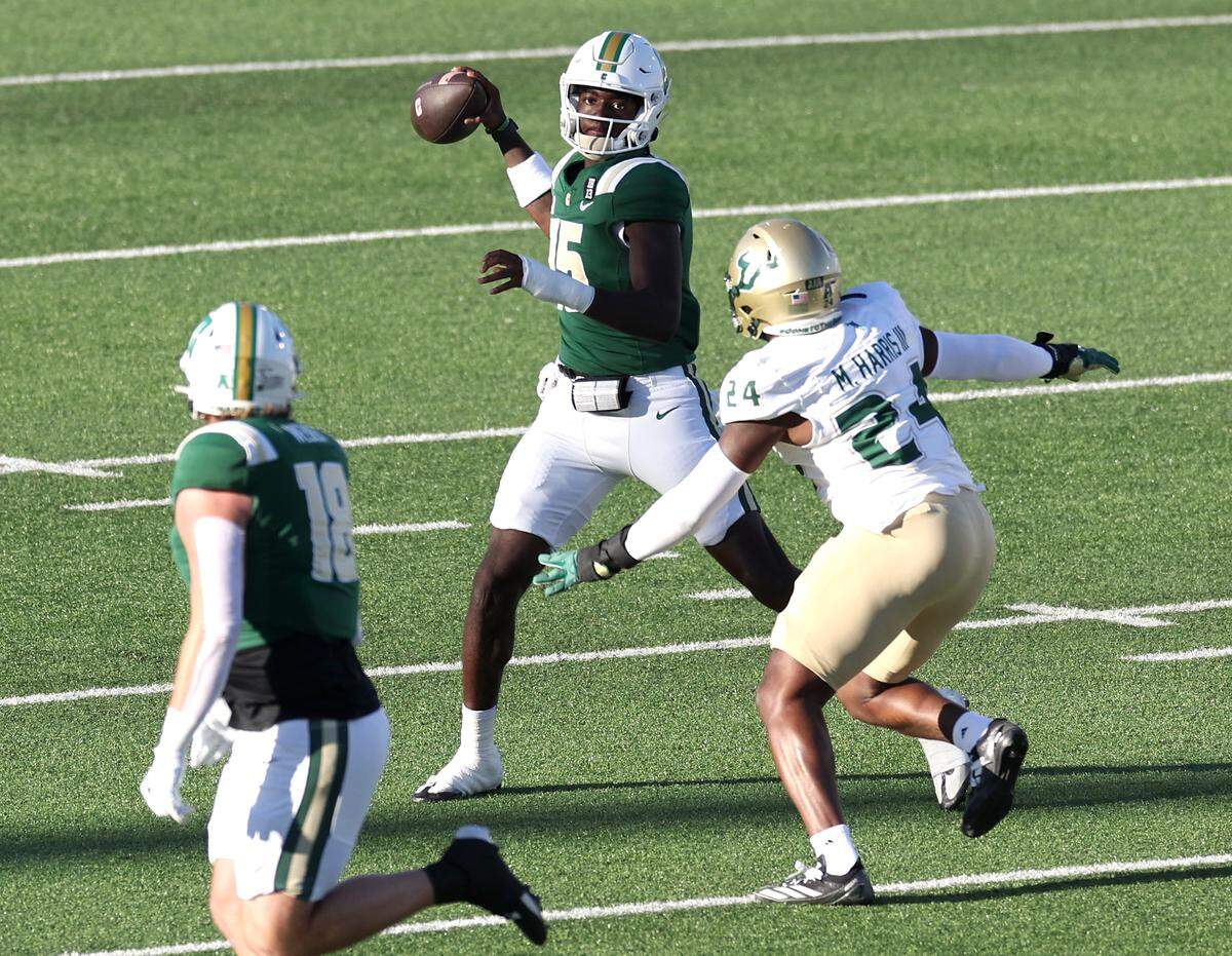 South Florida linebacker Mac Harris, right, rushes Charlotte 49ers quarterback Deshawn Purdie, center, as Purdie scrambles out of the pocket to pass to tight end Colin Weber, left, during action on Saturday, November 16, 2024 at Jerry Richardson Stadium.