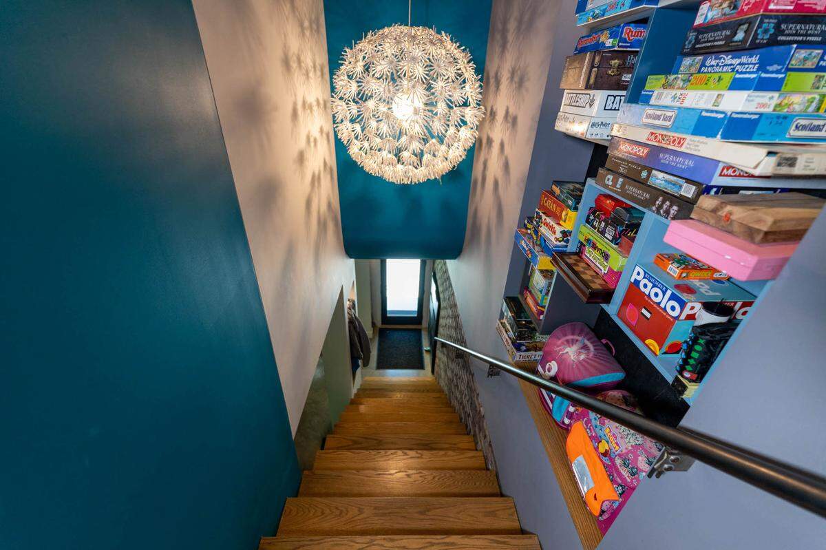 Near the top of the stairs to the second story are wall storage cubbies used for board games and books.