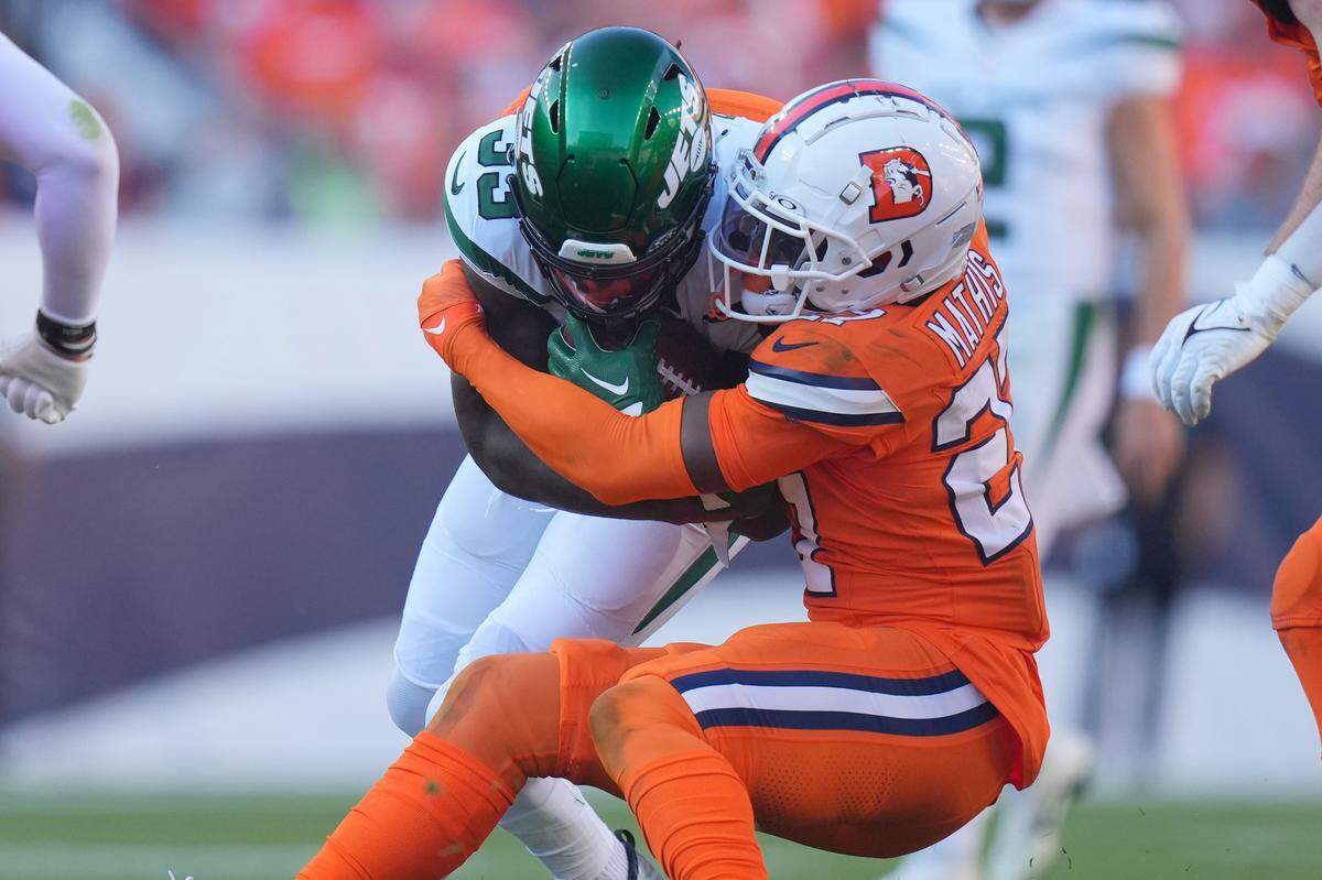 Oct 8, 2023; Denver, Colorado, USA; Denver Broncos cornerback Damarri Mathis (27) tackles New York Jets running back Dalvin Cook (33) in the second half at Empower Field at Mile High. Mandatory Credit: Ron Chenoy-USA TODAY Sports